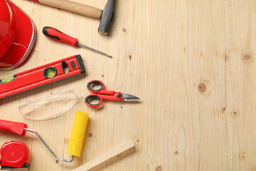 Flat lay composition with building level and other different construction tools on wooden...