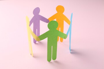 Equality concept. Paper human figures on pink background, closeup