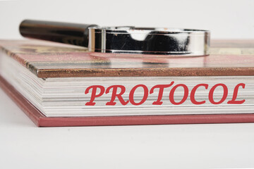 Protocol, text written on the end of the book with a magnifying glass on top on a white background