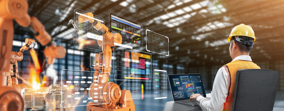 Technician or engineer work with robotic arms in factory