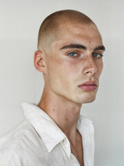 Fototapeta premium Bald young man with a bright personality. Stylish bald-headed person on white background