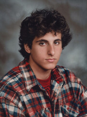 Fototapeta premium Portrait of a young man in the style of the 80s or 90s. Retro photo of a person dressed in vintage style. Nostalgic photo