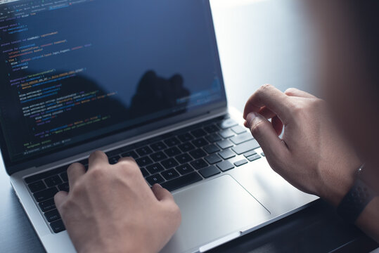 Developing programmer, software developer coding computer code on laptop computer. Digital software development. Website and mobile app design and coding technologies.