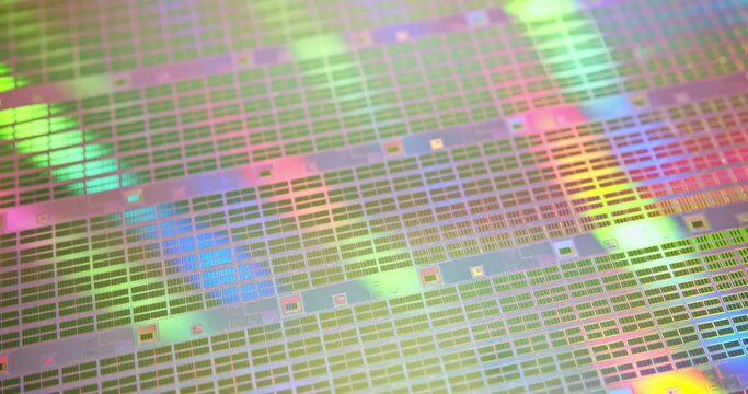 A close-up view of a silicon wafer's microprocessor circuit layout. The semiconductors or central processing unit CPU microchips are fabricated from a silicon wafer with patterned layers of materials.