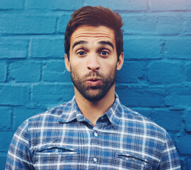 Man, wall and portrait with sigh of relief in city with fashion, confidence and outdoor with trendy...