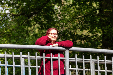 Portrait of a red-haired cheerful woman in the forest on a beautiful sunny summer day