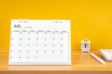July 2024, Monthly desk calendar for 2024 year on wooden table.