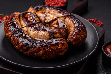 Fototapeta premium Delicious grilled sausage in the form of a ring with salt, spices