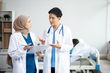 Hospital Ward Male and  Male Professional Asian Doctors Talk with a Patient, Give Health Care Advice, Recommend Treatment Plan