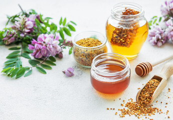 Raw organic bee pollen and honey in jars.
