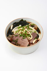 Beef and noodles soup in Asian style. Pho Bo soup. Sea cabbage with green onions in broth. Vertical photo. Copy space. Isolated object. Top view.