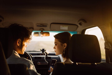 young couple in a car on a summer trip