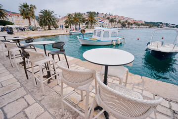 Cafe on promenade at harbour with beautiful white yachts in Hvar, Croatia