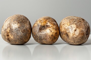 Fototapeta premium Three Raw Potatoes on Grey Background