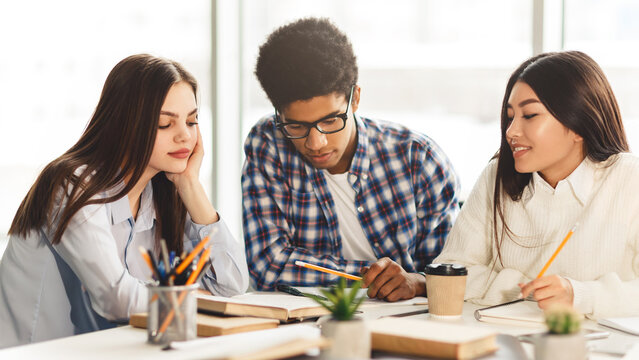 Education concept. High school students studying and reading together in library