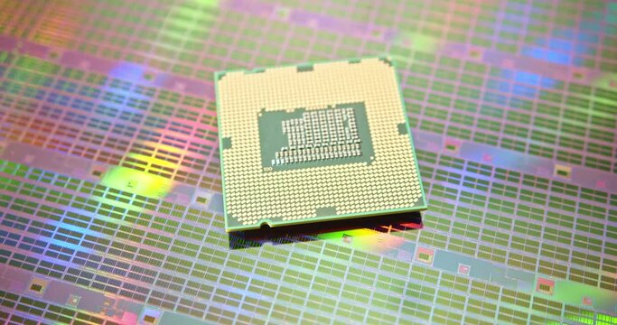 A close-up view of a silicon wafer's microprocessor circuit layout. The semiconductors or central processing unit CPU microchips are fabricated from a silicon wafer with patterned layers of materials.