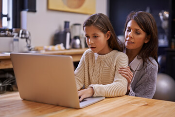 Mother, child and learning with laptop for support, care or browsing in the kitchen at home. Mom, daughter or kid typing on computer for social media, reading or helping girl on project or homework