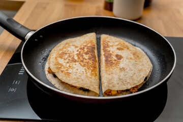 Chef at the kitchen preparing quesadillas with tofu and sweet corn