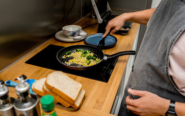 Chef at the kitchen preparing tofu scramble with vegetables