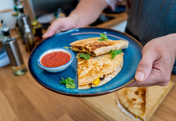 Chef at the kitchen preparing quesadillas with tofu and sweet corn