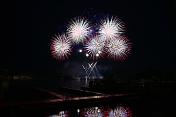 Firework. Beautiful colorful fireworks on the water surface with a clean black background. Fun festival and contest of Firefighters. Brno Dam - Czech Republic.