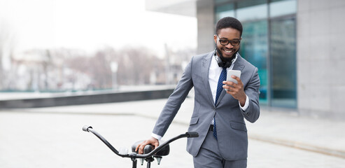 A professional black man on a bicycle is checking his phone in a cityscape. The atmosphere is vibrant and modern, emphasizing the fast-paced nature of urban life.