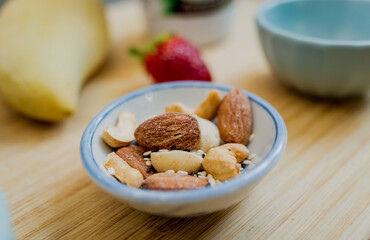 Cutting board with ingredients for preparing bowl of oats with strawberries and mango