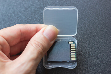 Male hand opening up the case of a sdxc memory card for Camera 