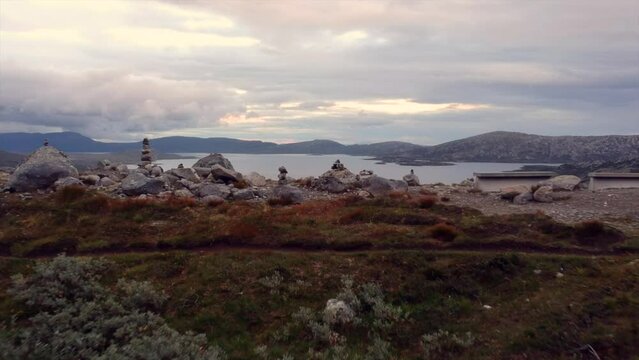 Flyby of rock formation with view of lake Vinstre in Norwegian mountains
