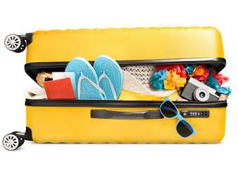 a full ajar suitcase with summer accessories, a passport and a camera lies on its side, on a white...