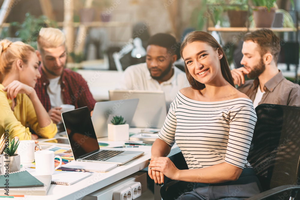 Poster a group of young professionals collaborate around a table in a modern office environment, engaging i