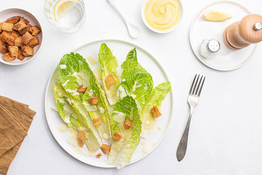 Top view of a freshly prepared Caesar salad on a white plate
