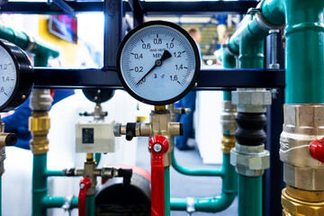 A pressure gauge with a scale for measuring the pressure of a liquid or gas in a confined space located at a pipe connection.