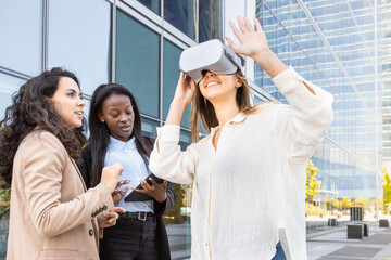 Three women testing virtual reality technology outdoors