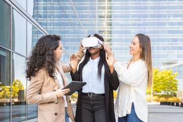 Three women testing virtual reality technology outdoors
