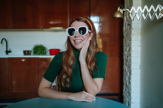 Comical 50s housewife wearing oversized sunglasses in kitchen