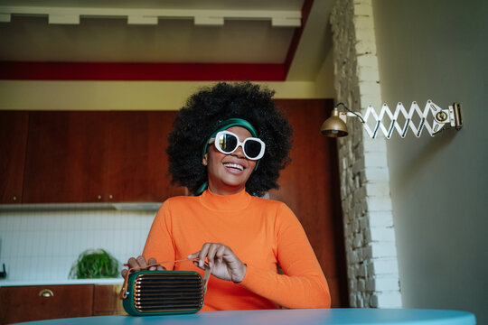Retro-themed photo of a cheerful Black African american woman with a vintage radio