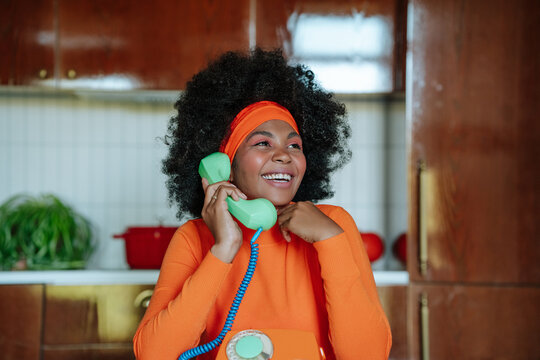 Joyful 1950s-inspired housewife chatting on vintage phone