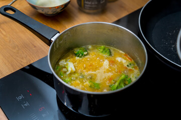Chef at the kitchen preparing lentils soup with cauliflower and broccoli