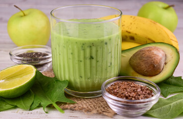 Green smoothie in a glass. Vitamin drink made from avocado, banana, spinach, lime.
