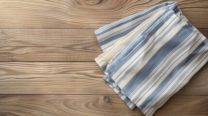 Blue and white striped kitchen towel folded on a wooden table.