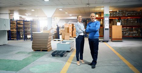 Arms crossed, collaboration and warehouse with portrait of business people together for delivery management. Logistics, shipping or supply chain with man and woman employee in factory or plant