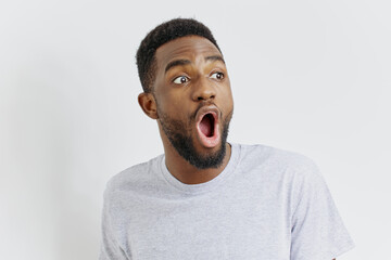 Shocked african american man with wide open mouth expressing astonishment against white background