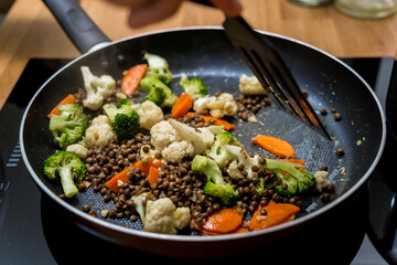 Chef at the kitchen preparing japanese buckwheat pasta with lentils