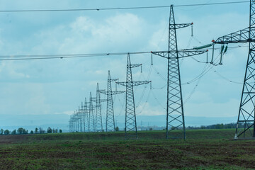 High voltage towers with sky background. Power line support with wires for electricity transmission. High voltage grid tower with wire cable at distribution station. Energy industry, energy saving