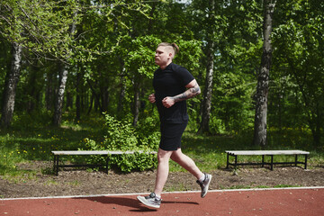 Caucasian male athlete jogging outdoors in a summer park