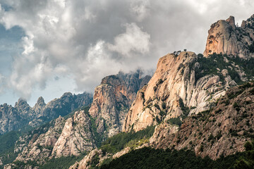 Dark clouds over the Aiguilles de Bavella, needle like rocky mountain peaks surrounded by pine forest and maquis in the centre of Corsica