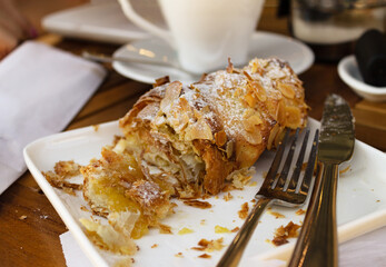 croissant made of puff pastry with almonds on a plate, on the table