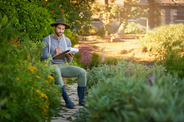 Man, gardening and clipboard for outdoor growth, planning and research of plants or flowers. Young...