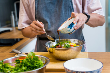 Chef at the kitchen preparing spicy glass noodle salad